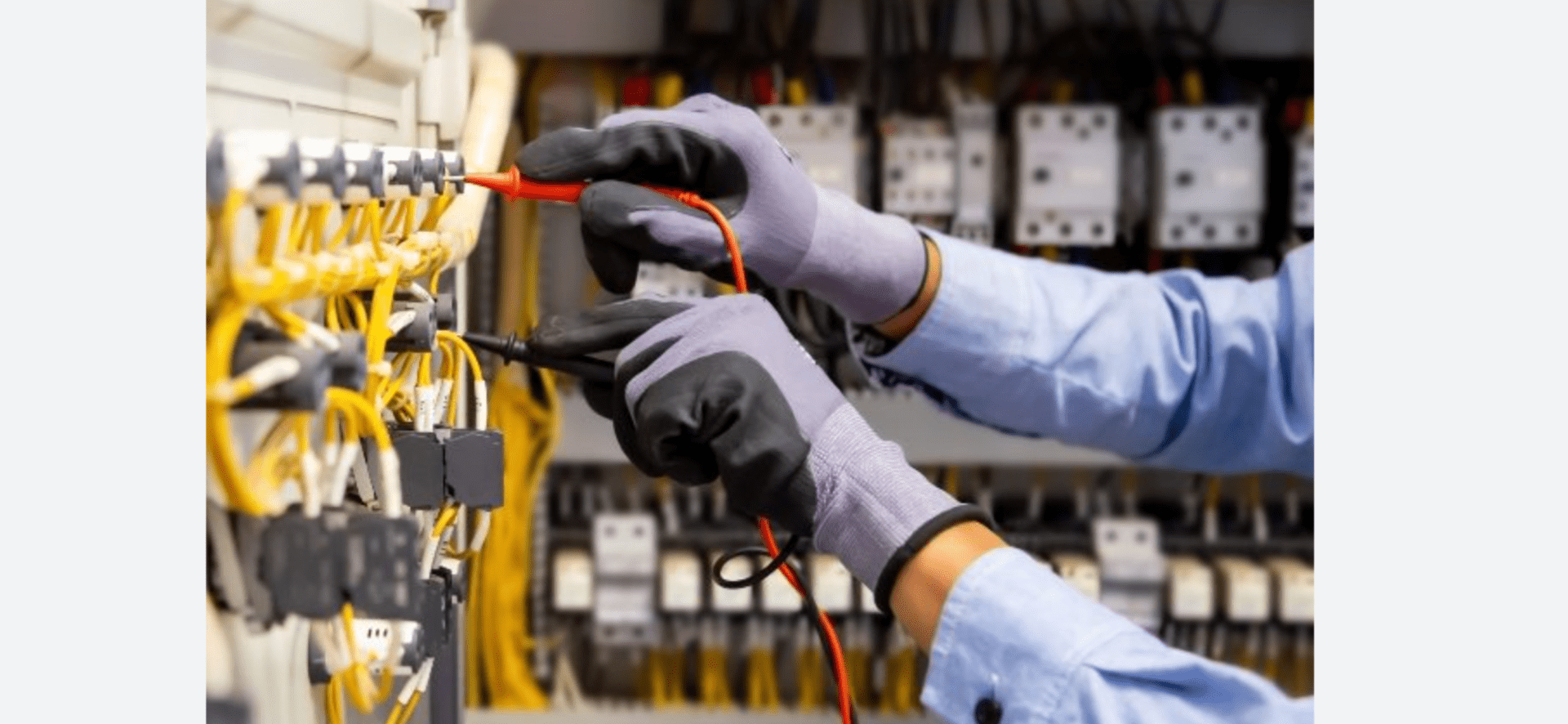 A person wearing gloves and holding wires